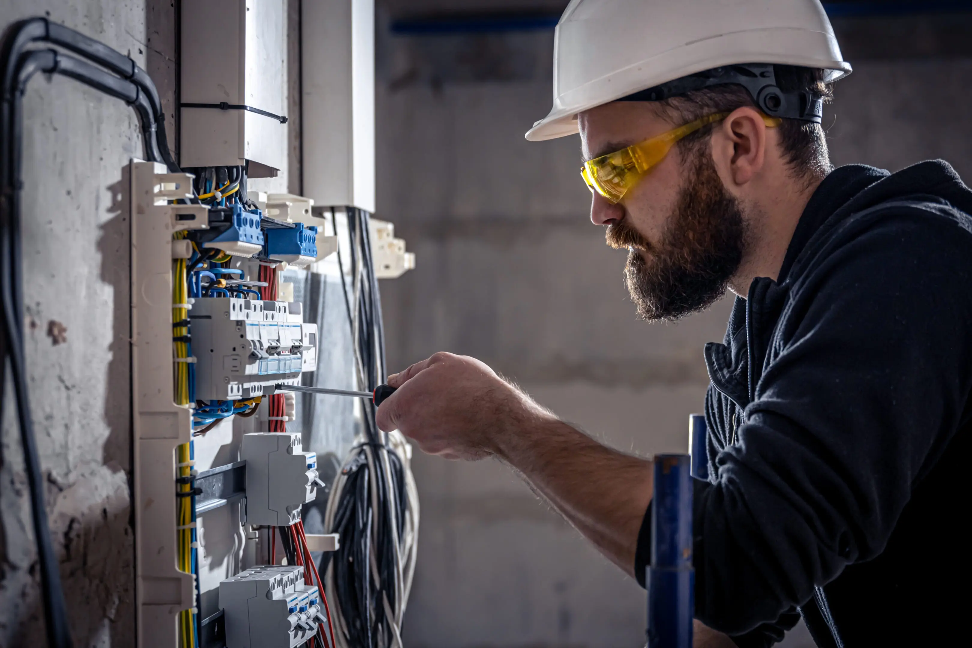 Electrician working on a circuit breaker panel.